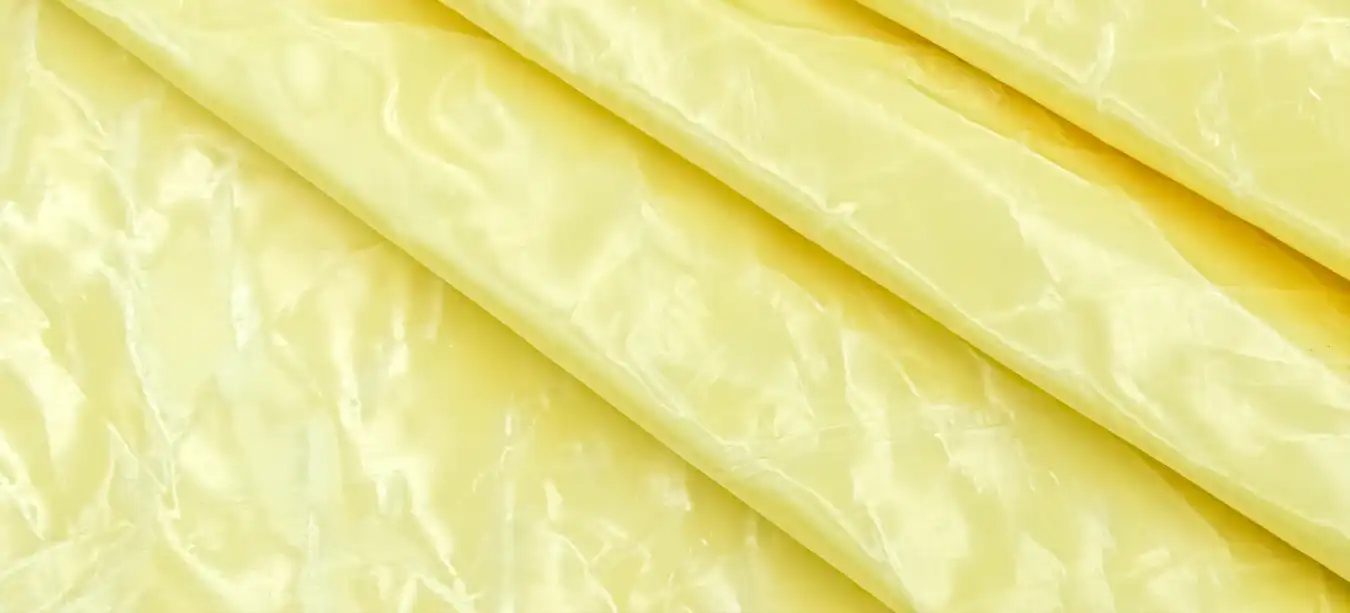 Neatly folded rolls of yellow ballistic fabric